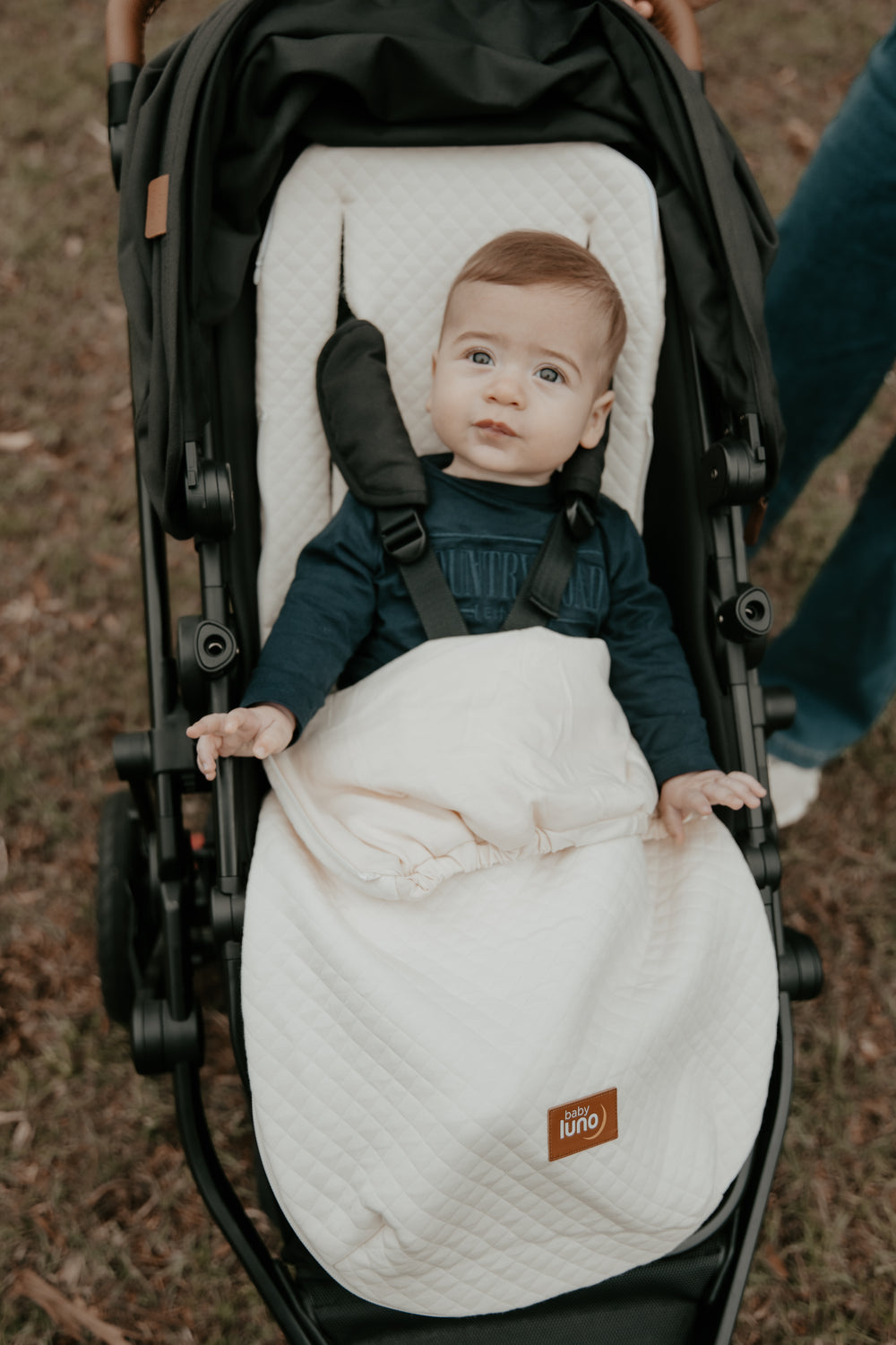 Baby in a stroller with the baby luno Lite Summer Footmuff Blanket