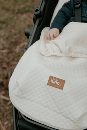 Baby in a stroller in the baby luno Lite Footmuff Pram Liner 