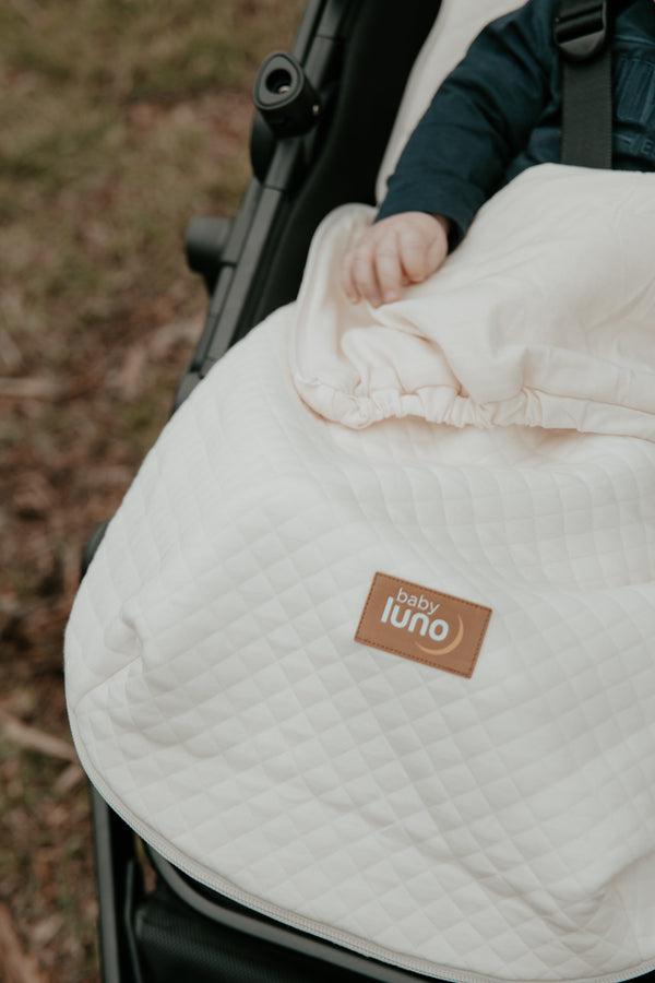 Baby in a stroller in the baby luno Lite Footmuff Pram Liner 