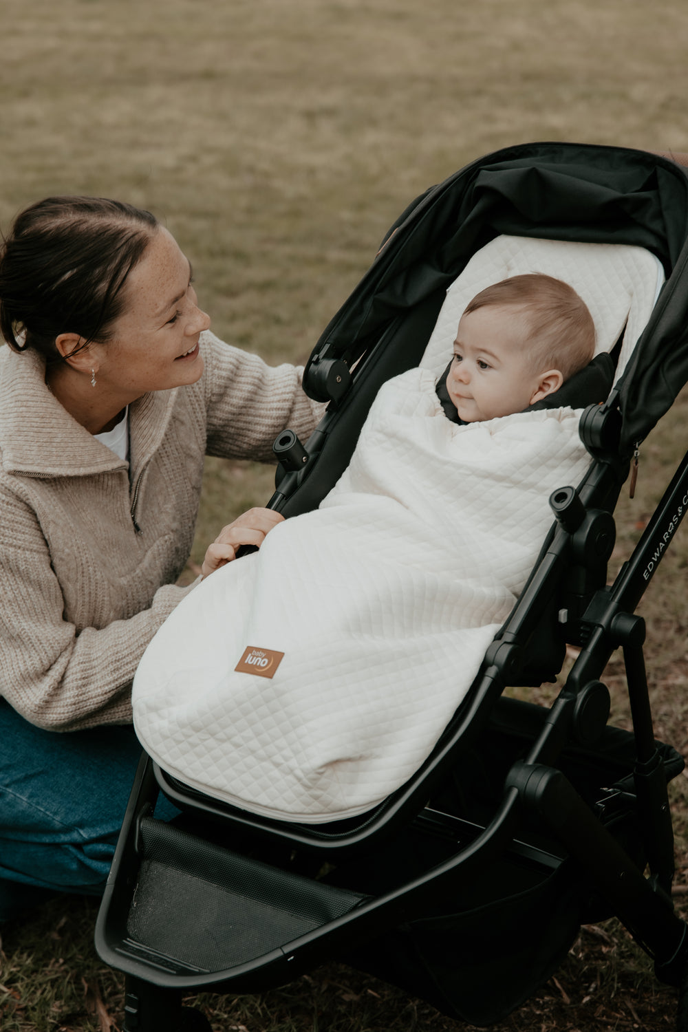 Baby in a stroller with the baby luno Lite Summer Footmuff Blanket