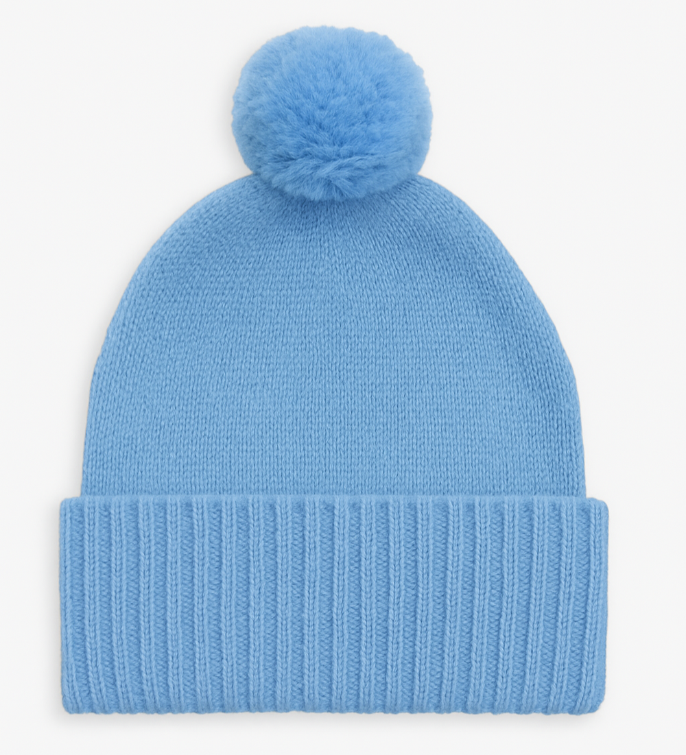 Blue knit beanie with a pom-pom on a white background
