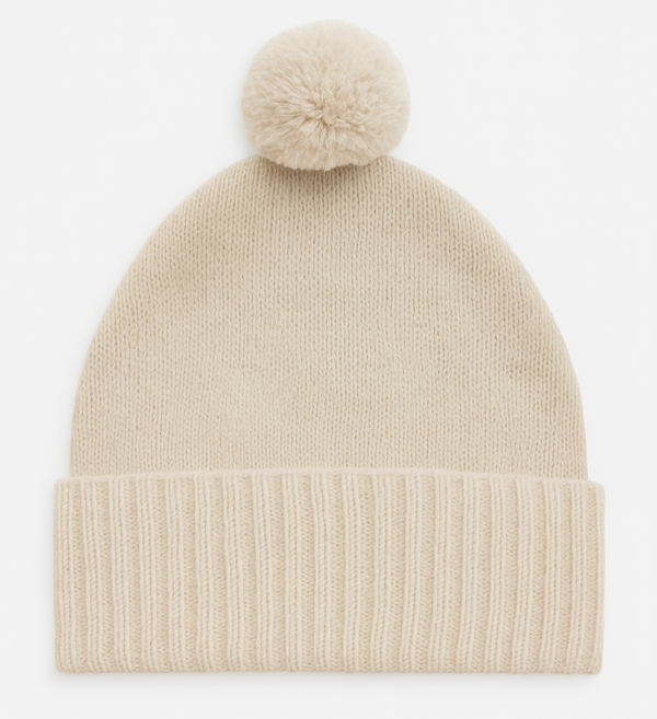 Beige knit beanie with a pom-pom on a white background